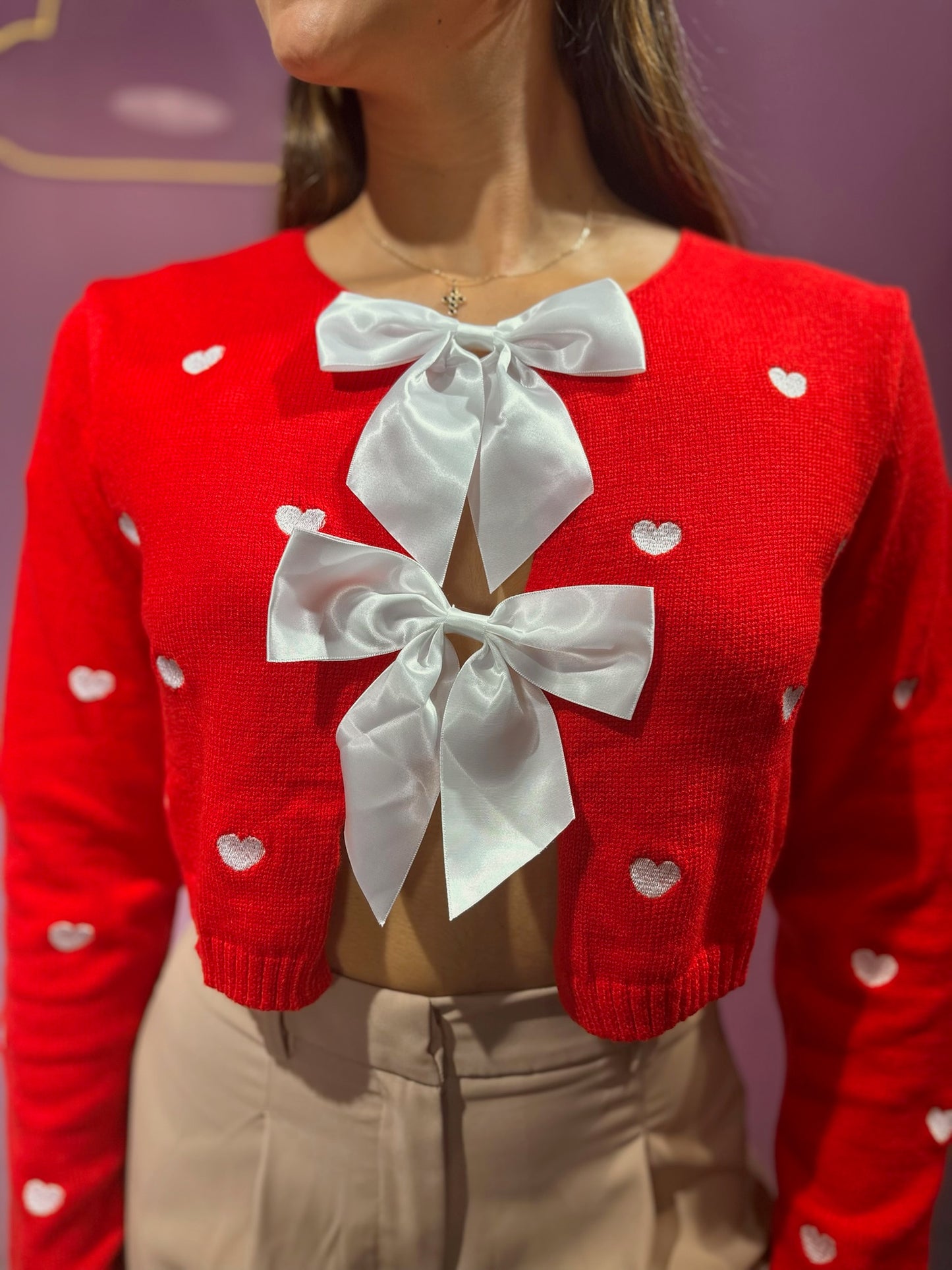 Suéter tejido rojo de corazones con lazos blancos