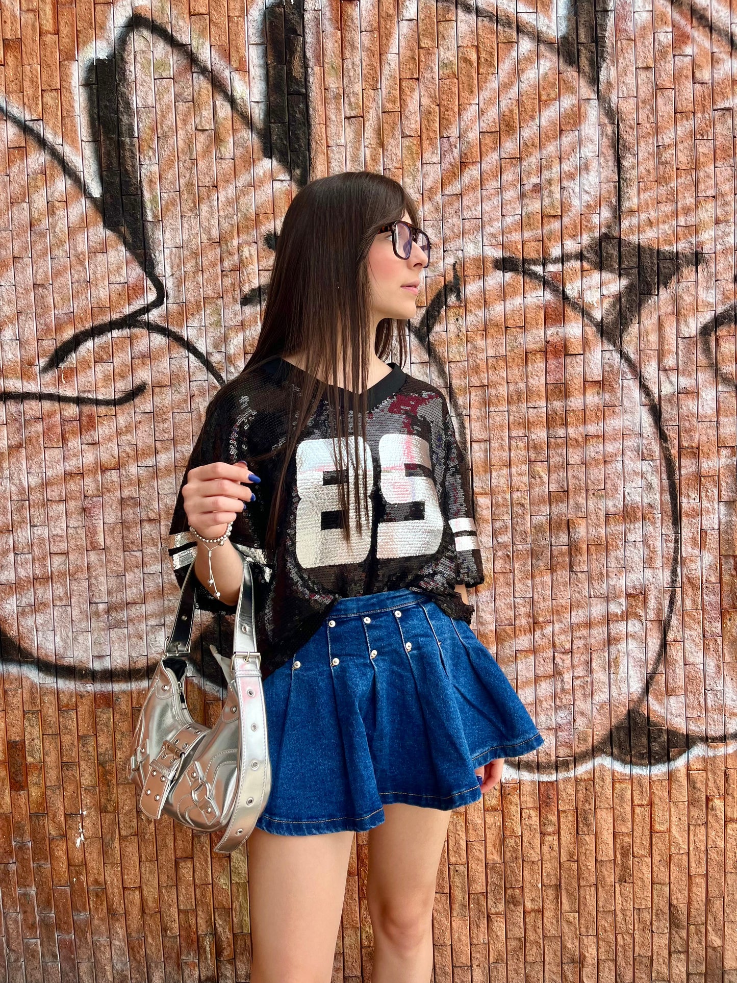 Falda de jean oscura plisada con tarches plateados