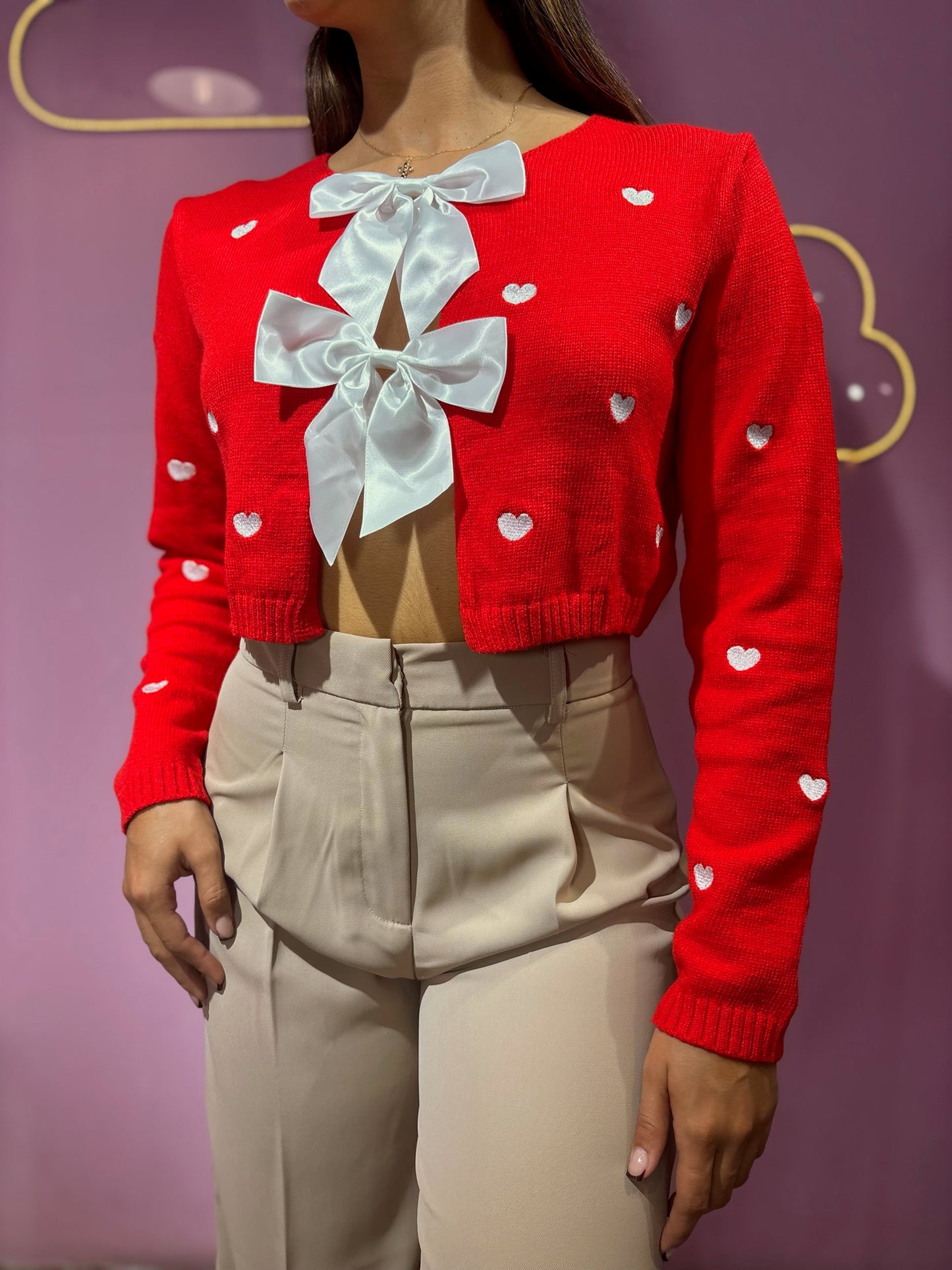 Suéter tejido rojo de corazones con lazos blancos