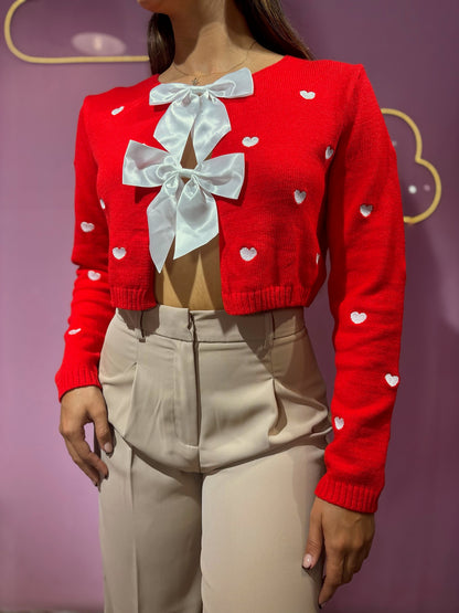 Suéter tejido rojo de corazones con lazos blancos