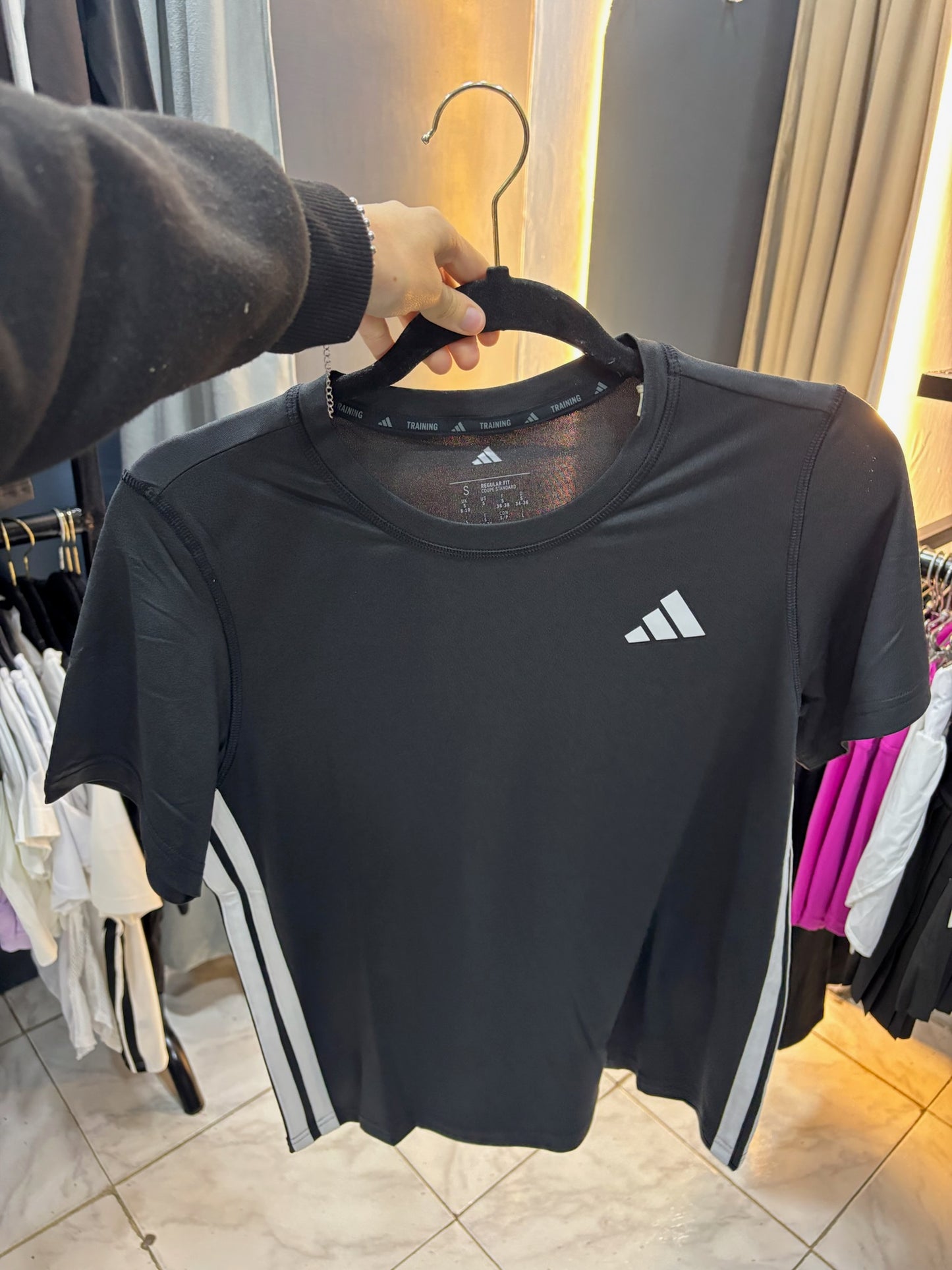 Franela deportiva de dama negra con franjas blancas a los costados ADIDAS