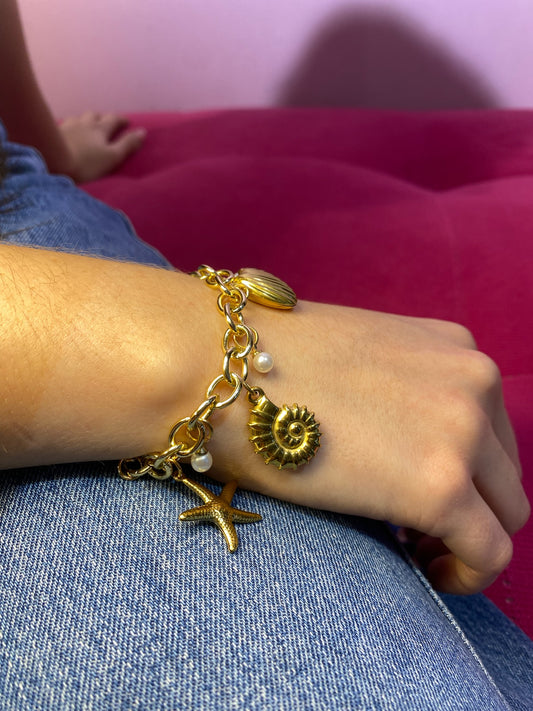 Brazalete playero de 4 dijes dorado de perlitas, caracoles, conchita y estrellita