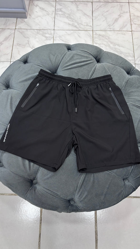 Short impermeable con cierre en los bolsillos y letras blancas a los costados de caballero deportivo Negro